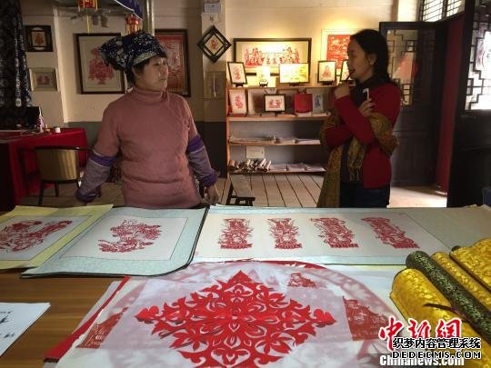 何克风经常向来访者不厌其烦地讲述剪纸壁画的奥妙。　孙志军 摄