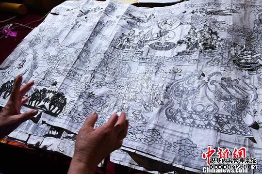 何克风将自己十几年前的设计底稿拿出来向记者展示。　杨艳敏 摄
